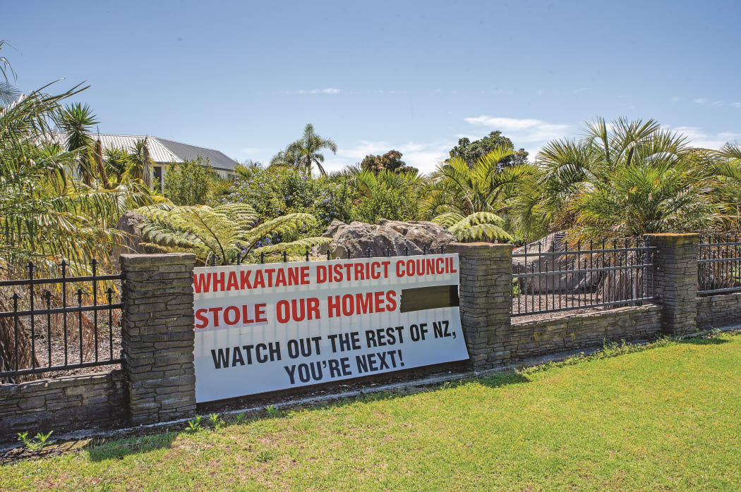 This sign on Rick and Rachel Whalley’s fence previously asked Whakatāne District Council to leave Awatarariki homes alone. It has now been updated to reflect the loss of their home.