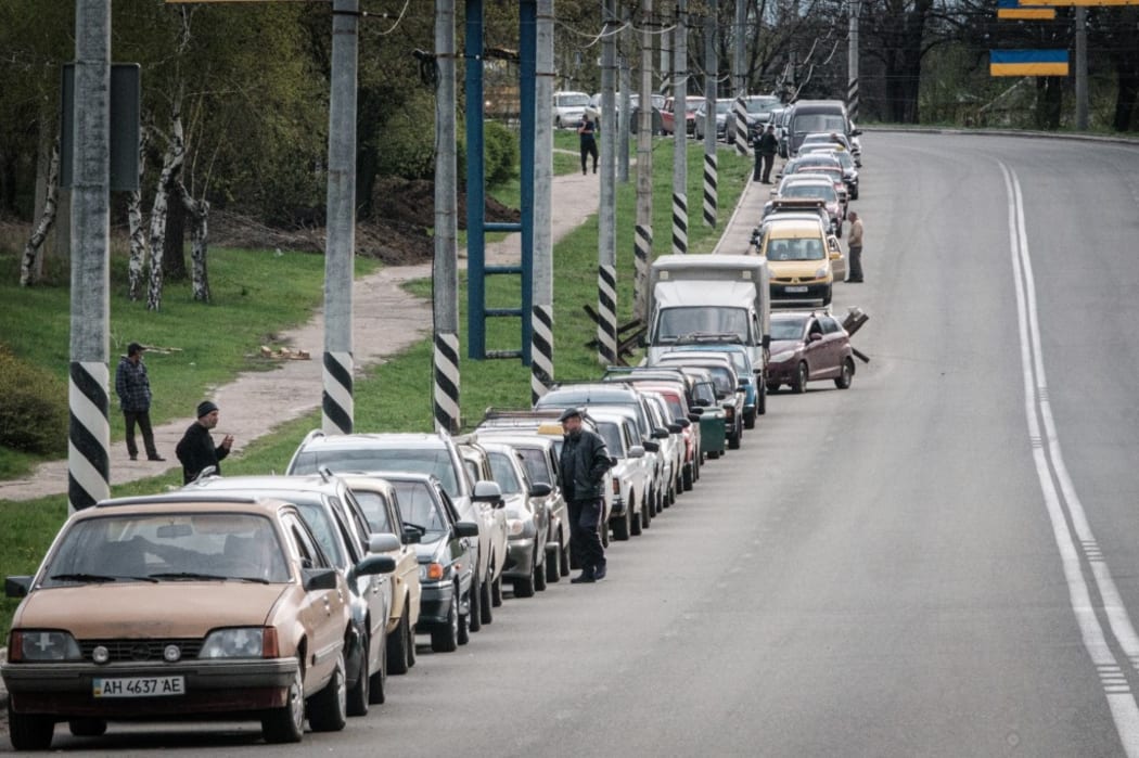 Local residents wait in line with their car to fill up with liquefied natural gas near a petrol station in Kramatorsk, eastern Ukraine, on April 21, 2022.