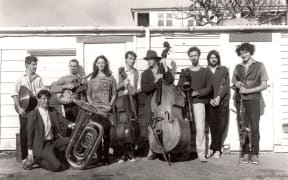 The nine members of the Braille Collective circa 1985 with instruments