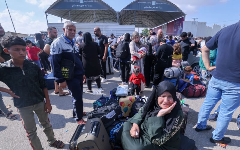 Palestinians, some with foreign passports hoping to cross into Egypt and others waiting for aid wait at the Rafah crossing in the southern Gaza strip, on October 16, 2023. The death toll from Israeli strikes on the Gaza Strip has risen to around 2,750 since Hamas’s deadly attack on southern Israel last week, the Gaza health ministry said October 16. Some 9,700 people have also been injured as Israel continued its withering air campaign on targets in the Palestinian coastal enclave, the Hamas-controlled ministry added. (Photo by Mohammed ABED / AFP)