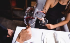 Couple clinking wine glasses.
