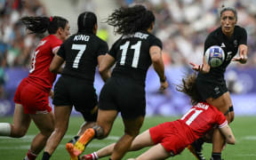 New Zealand's Sarah Hirini (R) passes the ball during the women's gold medal rugby sevens match between New Zealand and Canada during the Paris 2024 Olympic Games at the Stade de France in Saint-Denis on July 30, 2024. (Photo by CARL DE SOUZA / AFP)