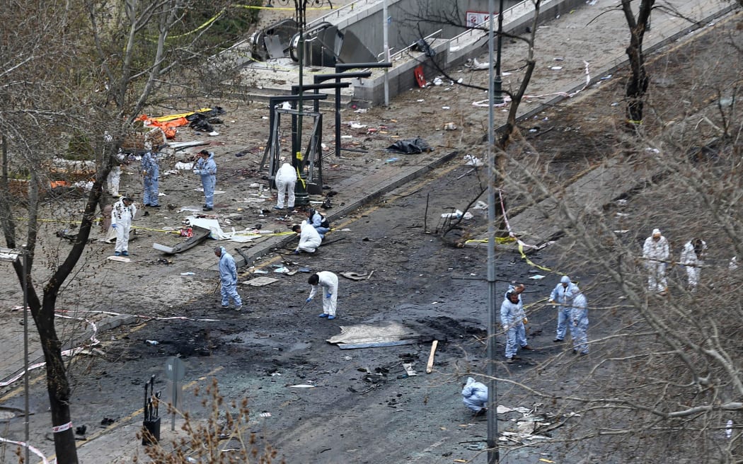 Forensic experts investigate the scene the day after a suicide car bomb in central Ankara killed at least 34 people and wounded 125.