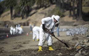 Crews clean oil from the beach at Refugio State Beach.