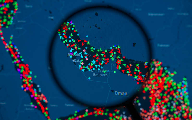 A MarineTraffic map showing ship movements in the Strait of Hormuz is pictured through a magnifying glass in this photo illustration, as commercial vessel traffic through the key oil shipping lane drops sharply amid the escalating conflict involving Iran. Taken in Brussels, Belgium, on March 15, 2026. (Photo by Jonathan Raa/NurPhoto) (Photo by Jonathan Raa / NurPhoto via AFP)