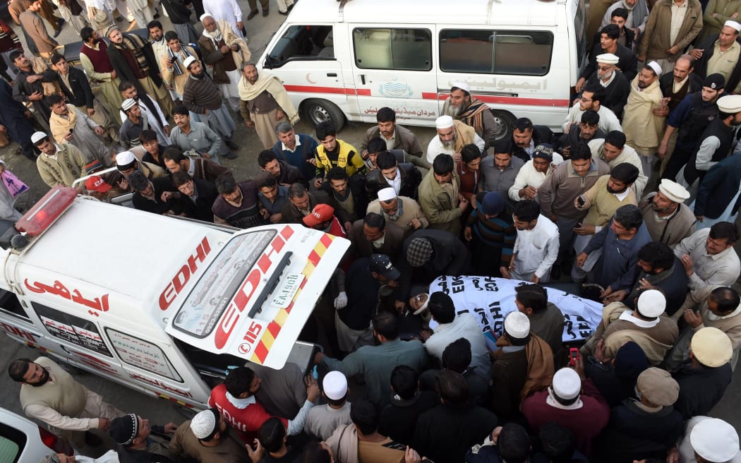Pakistani mourners transport a bomb victim from the hospital in Mardan.