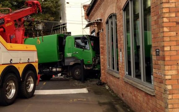 The truck rolled into the brick building.