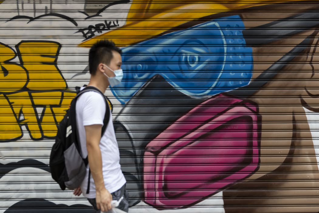 A man wearing a face mask as a precautionary measure against Covid-19 walks on a street in Hong Kong.