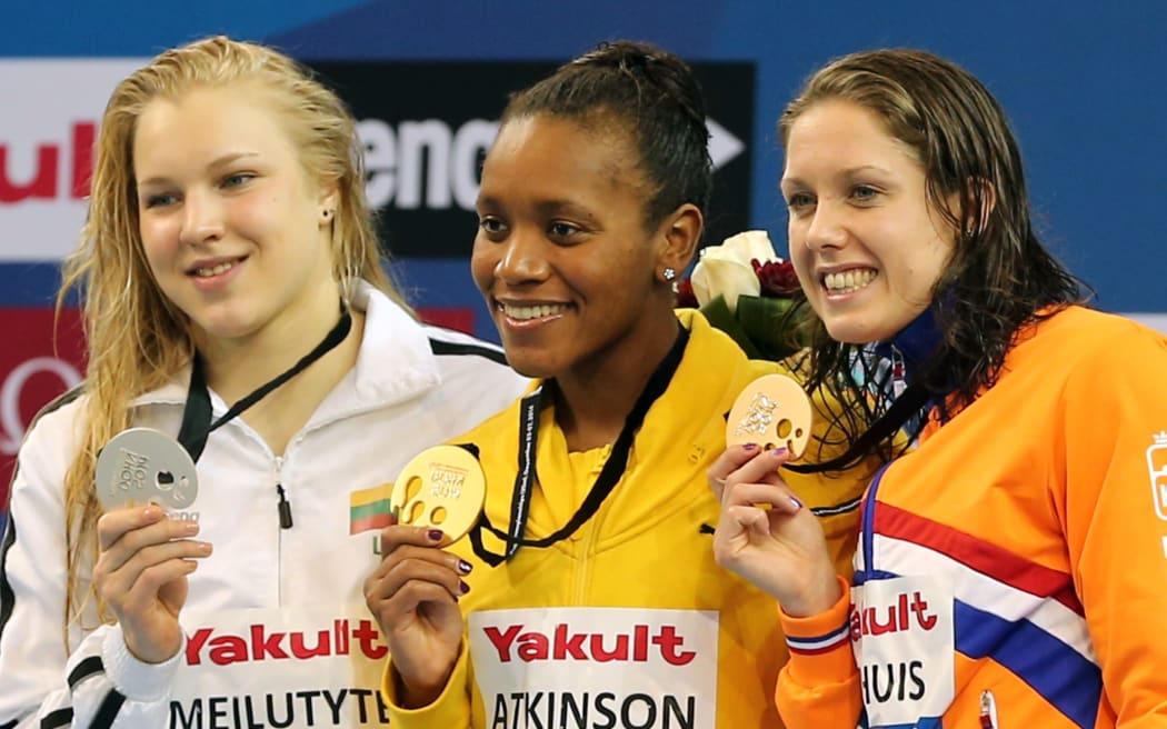 Alia Atkinson of Jamaica poses with her gold medal she won in the women's 100m Breaststroke during the 12th FINA World Swimming Championships in Doha.