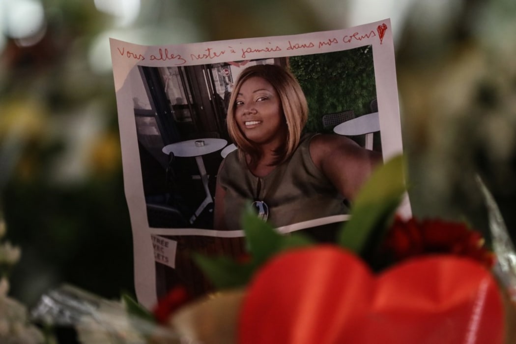 The portrait of a victim is displayed among candles and flowers on the doorsteps of the Notre-Dame de l'Assomption Basilica in Nice on October 30, 2020, a day after a knife attacker killed three people