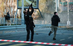 A police officer fires at a drone during attacks in Kyiv on 17 October, 2022.