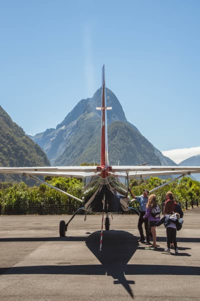 Small plane with Mitre Peak in background.