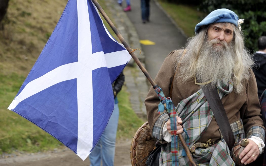 A Pro-independence supporter holds the Scottish flag during a rally in Edinburgh.