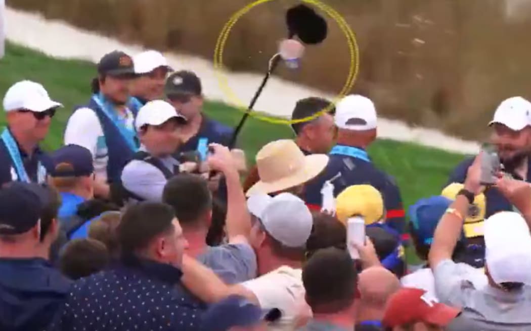 A beer is launched from the Ryder Cup crowd towards Rory and Erica McIlroy. (Supplied)