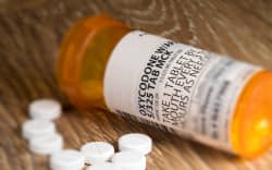 Tiltshift effect of prescription bottle for Oxycodone tablets and pills on wooden table for opioid epidemic illustration