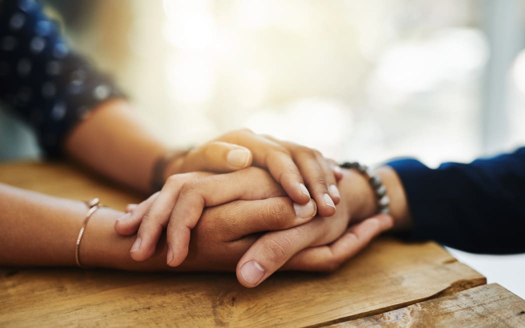Holding hands, support and comfort of two people talking through a difficult problem. Closeup of friends showing care and love through a hard time, consoling each other and bonding.