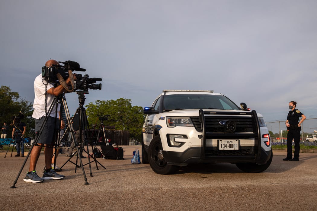 A Bryan Police Department officer maintains a perimeter near the scene of a shooting at Kent Moore Cabinets on April 8, 2021 in Bryan, Texas.