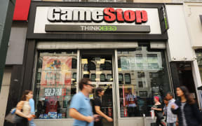 (FILES) In this file photo taken on September 15, 2019 people pass a GameStop store in lower Manhattan in New York City. G
