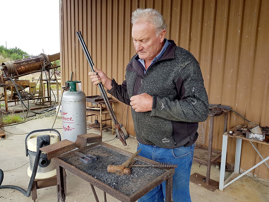 Allan Birchfield eyes the finished gold piece within the mould.