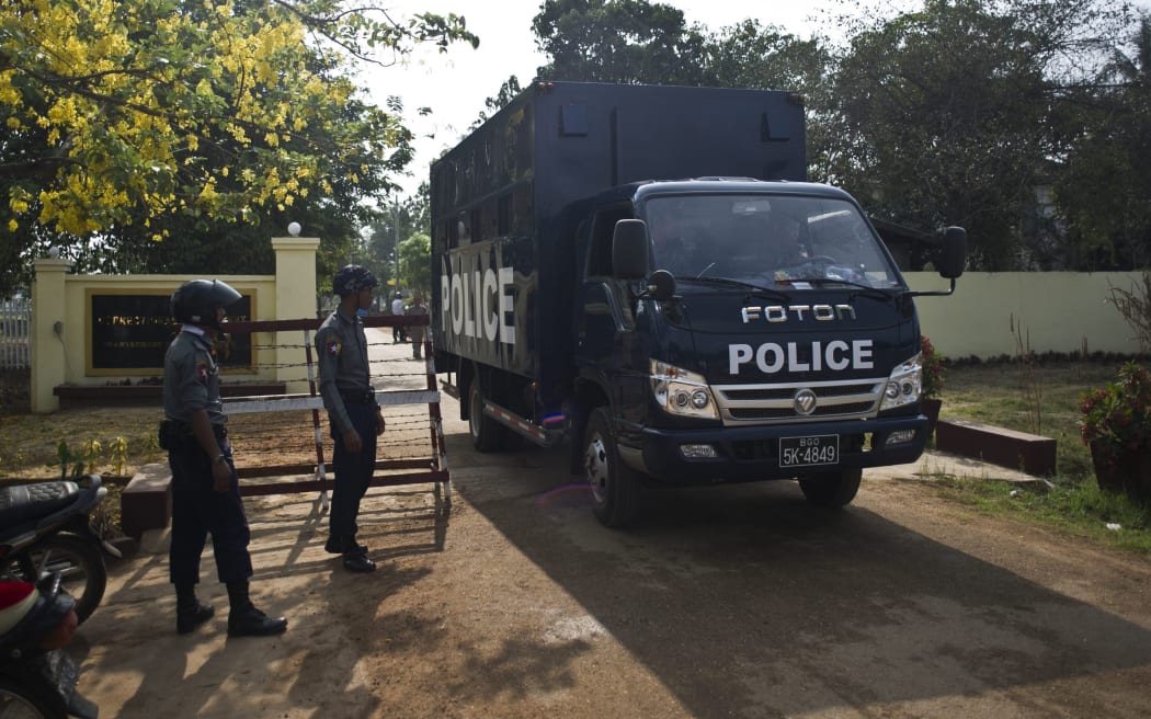A prison truck and police officers stand guard in front of Tharrawady Central Prison following a prisoners' release in Tharrawady town, Bago Region in Myanmar.