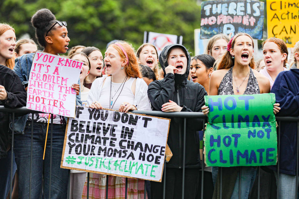 Protestors with banners at the Climate Strike at Parliament April 2021: "You Know it's a Problem when it's Hotter than Me", "If You Don't Believe in Climate Change Your Mom's a Hoe", and "Hot Climax not Hot Climate".