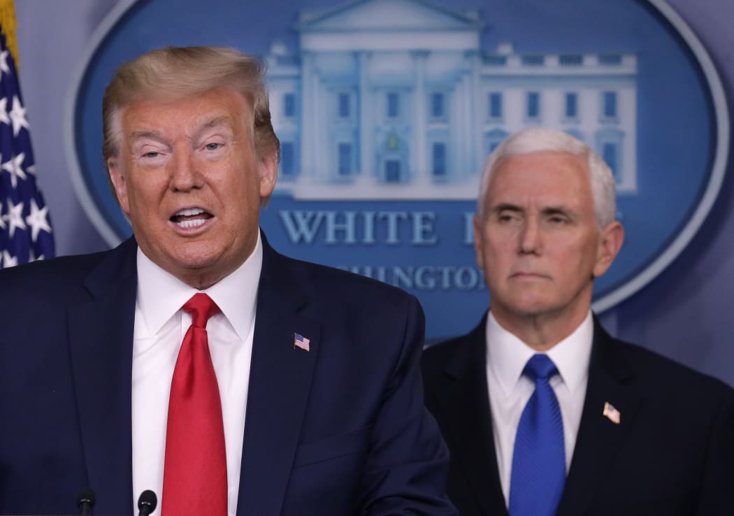 President Donald Trump is flanked by Vice President Mike Pence while speaking during a news briefing on the latest development of the coronavirus outbreak in the US at the White House on 18 March.