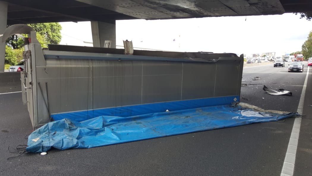 The truck lay on its side after hitting the overbridge.