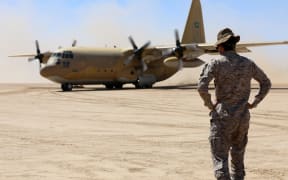 Saudi soldiers stand guard as a Saudi air force cargo plane, carrying aid, lands at an airfield in Yemen's Marib, on 8 February, 2018.