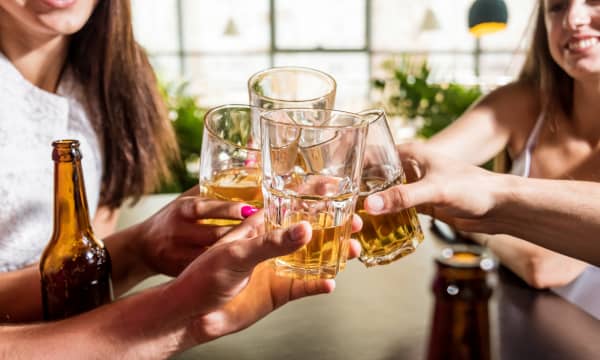 Cheerful friends in the pub. Drinking beer, talking, having fun. Meeting friends after work