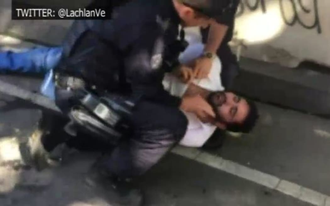 Police detain a man after the Flinders Street incident.