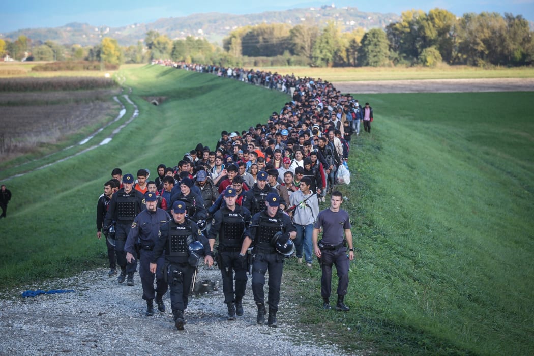 Around 2000 refugees are escorted by the Slovenian police as they walk towards a refugee camp in Brezice, Slovenia.