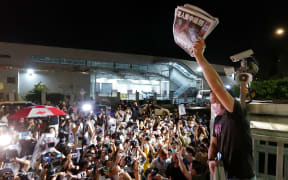 An Apple Daily journalist holds freshly-printed copies of the newspaper's last edition to be distributed to supporters gathered outside their office in Hong Kong early on June 24, 2021,