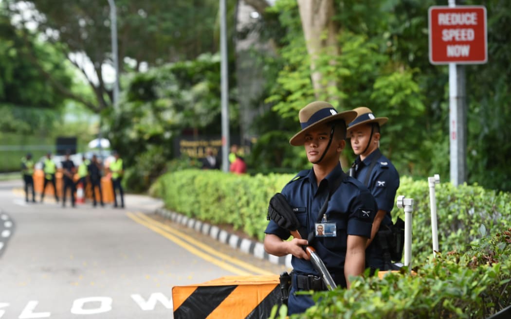 Armed Gurkhas from the Singapore police force stand guard along the road leading to the Shangri-La hotel.