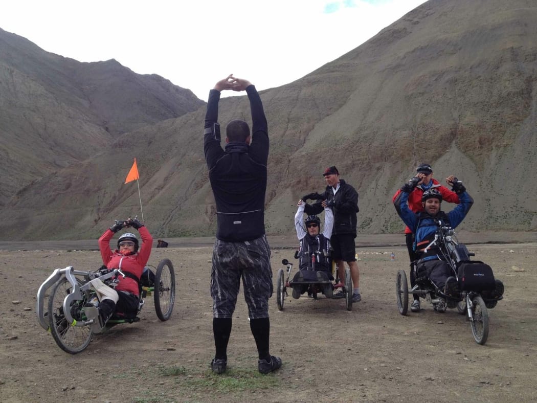 Team member Stuart Laughton puts the wheelies through their stretches before attempting a Tibetan pass.