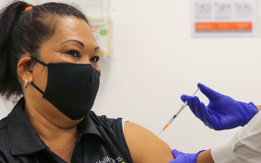 A woman receives a dose of the Pfizer/BioNTech Covid-19 vaccine during the first rollout of vaccinations in Australia at the Castle Hill Medical Centre in Sydney on February 21, 2021.
