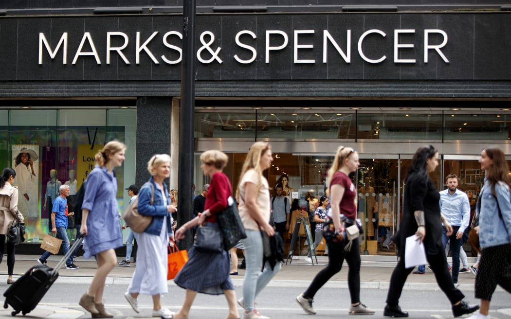 Shoppers walk past a Marks & Spencer shop on Oxford Street in central London on June 19, 2018. Major UK retailers are increasingly facing tough times in the face of intense online competition from the likes of US giant Amazon. Clothing-to-food retailer Marks & Spencer is meanwhile shutting more than 100 UK stores as it looks to shift at least one third of sales online. (Photo by Tolga Akmen / AFP)