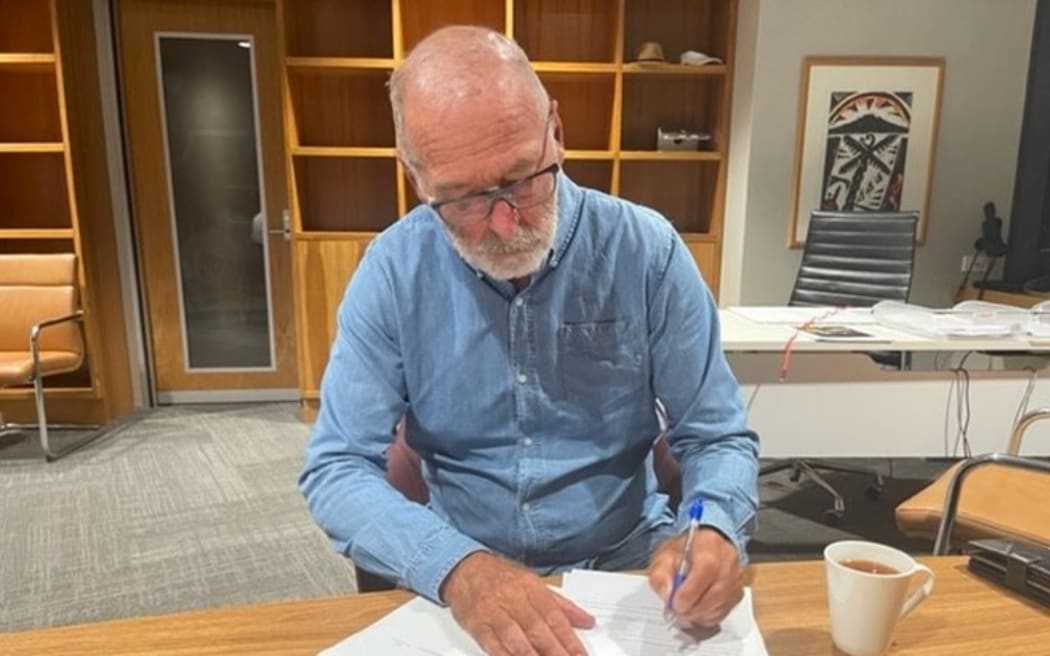 Auckland Mayor Wayne Brown signing a formal declaration calling a state of emergency for the region, on Friday 27 January, 2023