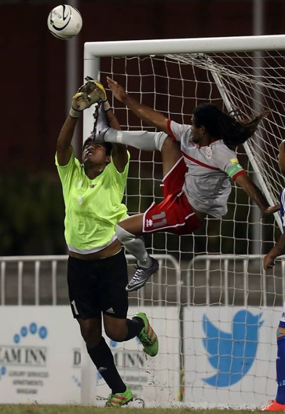 New Caledonia's Bertrand Kai challenges for the ball with Samoa goalkeeper Faalavelave Matagi.