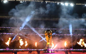 Fireworks go off around a FIFA World Cup trophy replica ahead of the Qatar 2022 World Cup semi-final football match between France and Morocco at the Al-Bayt Stadium in Al Khor, north of Doha on December 14, 2022. (Photo by Kirill KUDRYAVTSEV / AFP)
