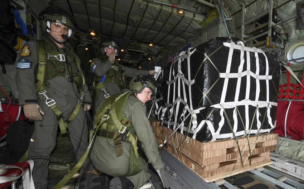 Flight Sergeant David Cresswell (left), Corporal Toni Thompson and Sergeant Ethan Moran (back), Air Loadmasters from the Royal New Zealand Air Force’s No.40 Squadron, prepare for the airdrop.