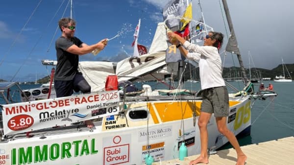 Dan Turner celebrates finishing the Mini Globe Race with champagne in Antigua, in the Caribbean Sea.