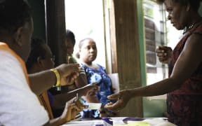 Election officials assist a women preparing to cast her vote during the 2014 elections.