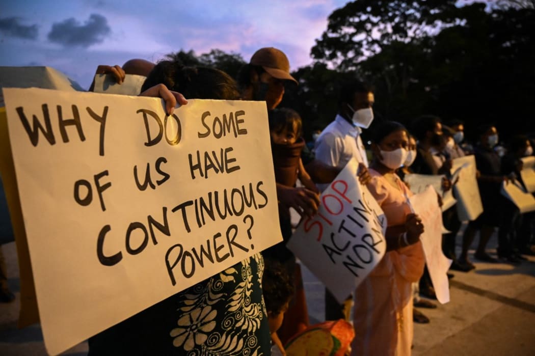 Protesters hold banners and placards during a demonstration against the surge in prices and shortage of fuel and other essential commodities in Colombo on April 1, 2022.