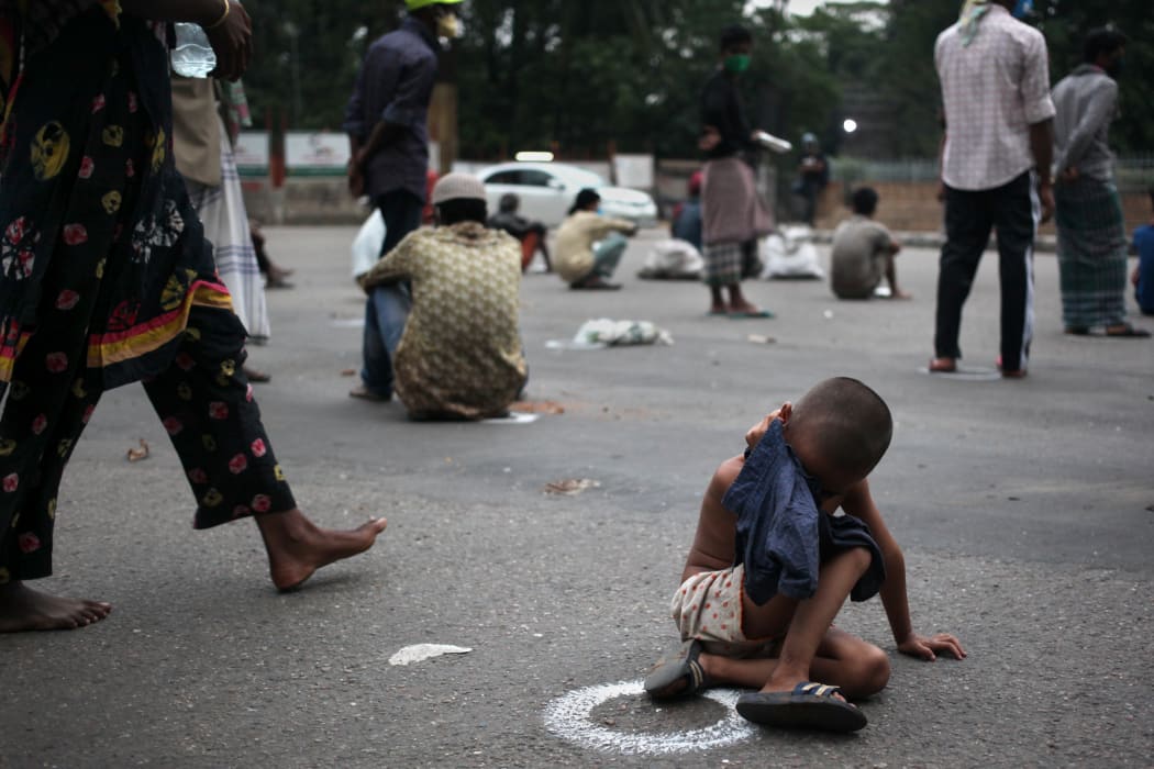 Homeless people wait for free Iftar package at a street on the first day of Ramadan during a government-imposed nationwide lockdown as a preventive measure against the COVID-19 coronavirus in Dhaka, Bangladesh on Saturday, Apr. 25,2020. (Photo by Syed Mahamudur Rahman/NurPhoto)