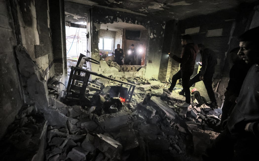 People inspect the wreckage of a building that was housing a group of militants and was hit by rockets during an Israeli army raid in the Jenin camp.