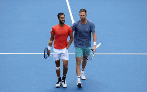 Yuki Bhambri of India (L) talks with partner Michael Venus of New Zealand during the 2025 US Open.