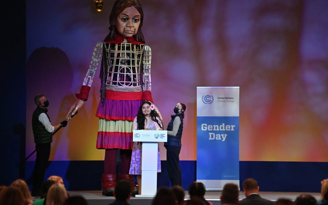 Little Amal, a giant puppet depicting a Syrian refugee girl, arrives on stage as Brianna Fruean, a Samoan member of the Pacific Climate Warriors, delivers a speech during the COP26 UN Climate Change Conference in Glasgow on November 9, 2021.