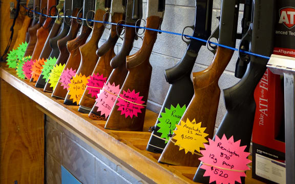 Rifles standing upright in rack with flouro price tags