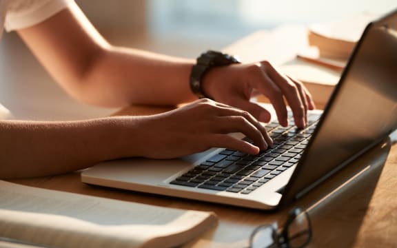 Hands of person typing on laptop keyboard