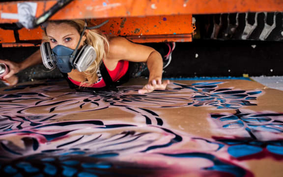 Artist Hayley King, aka Flox, working on a mural in Hamilton
